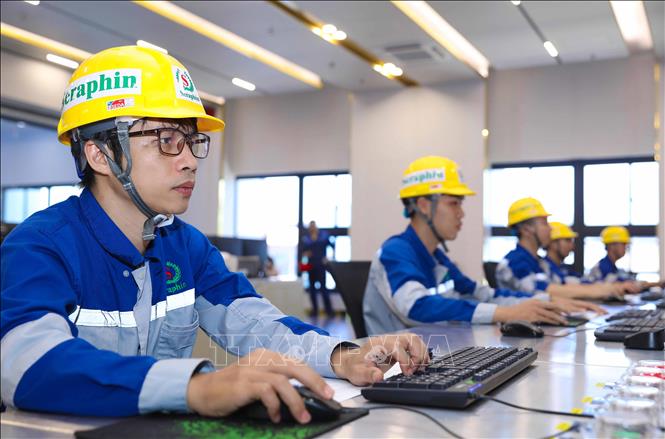 Các kỹ sư đang vận hành hệ thông xử lý rác thải. Ảnh: Thành Phương - TTXVN